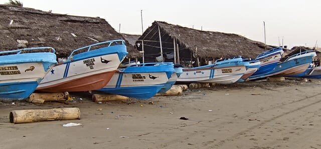 Small fishing boats line the beach of Crucita